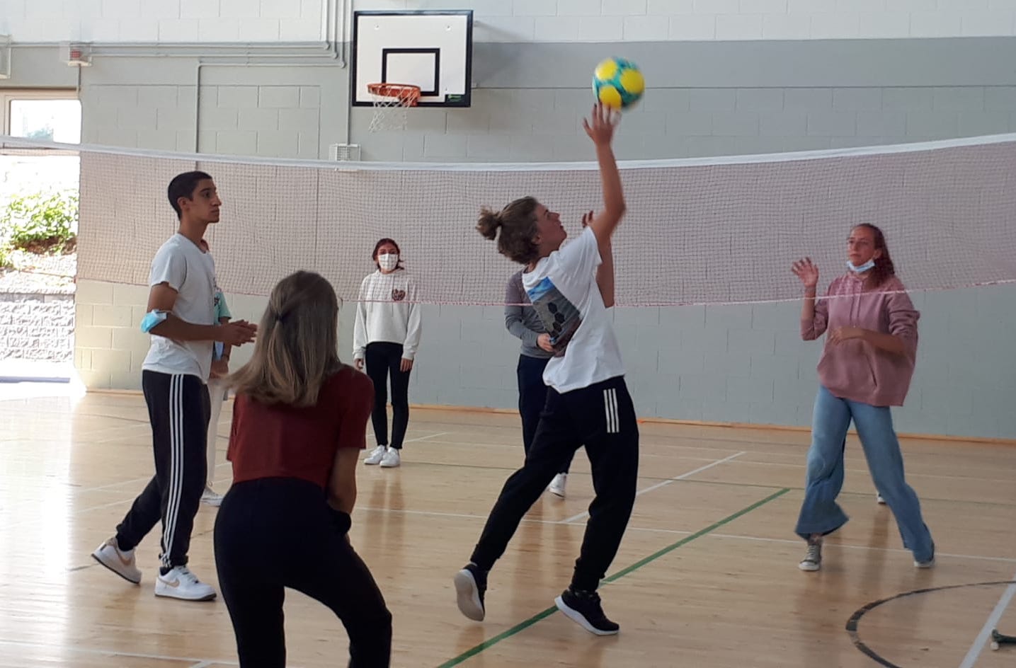 Students play a game of volleyball in the sports hall